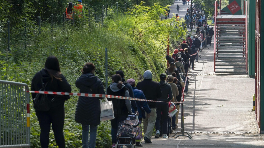 Multicultural coworkers enthusiastically watching something on mobile device