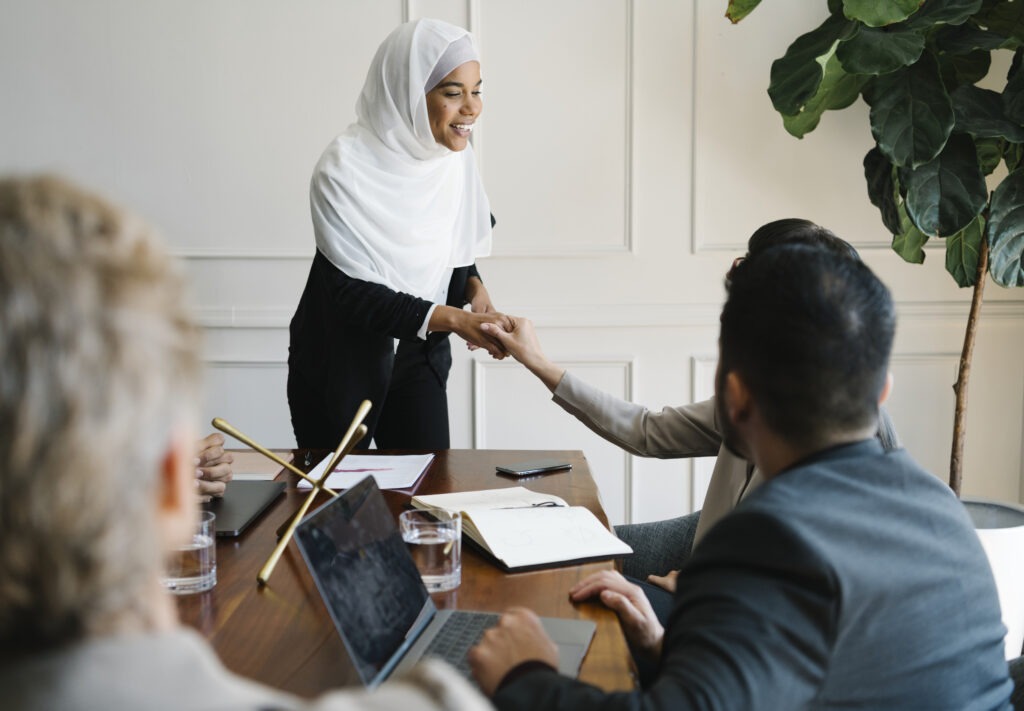 Multicultural coworkers enthusiastically watching something on mobile device